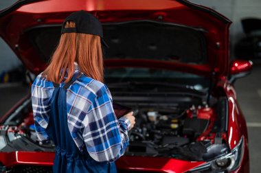Kafkas kadın oto tamircisi hataları teşhis etmek için özel bir bilgisayar kullanıyor.