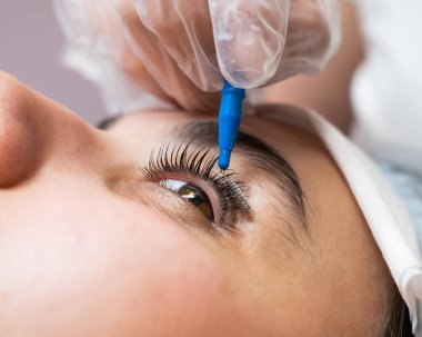 Üstat, kaplama işleminden sonra müşterinin kirpiklerini tarar.