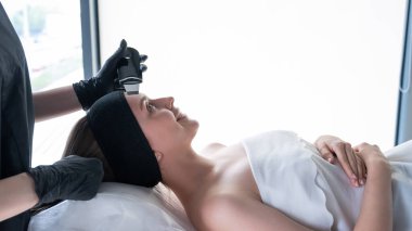 Ultrasonik temizlik prosedürü uygulayan bir kadın. Donanım kozmetolojisi