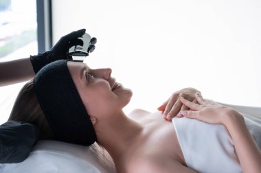 Ultrasonik temizlik prosedürü uygulayan bir kadın. Donanım kozmetolojisi