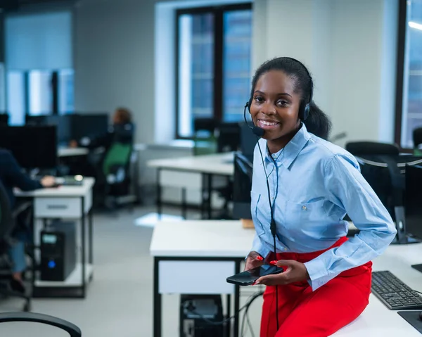 African female call center employee using smartphone