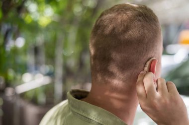 Bir adamın kulağına yakın çekim cihazı.