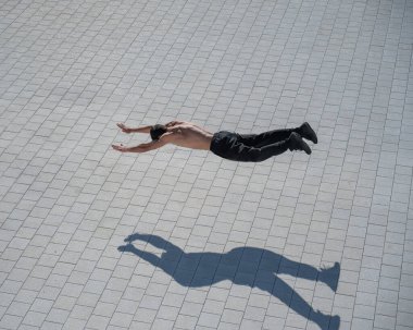 Açık havada uçan bir adam şınav çekiyor.