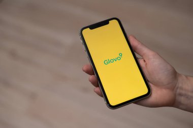 3 Aralık 2022 Almaty Kazakistan: Glovo ile akıllı telefon tutan yüzsüz kadın