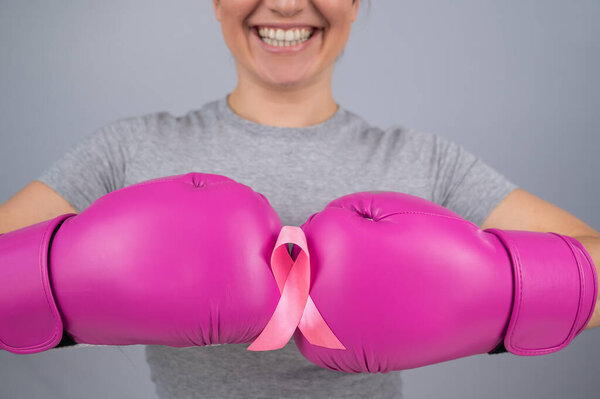 Close-up of womens boxing gloves and pink ribbon
