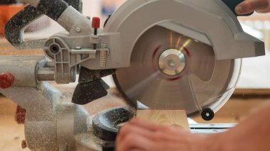 Usta atölyede dairesel testere ile tahtayı keser.