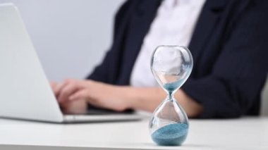 Kum saatinin süresi doldu. İş kadını laptopunu kapatır ve gider.