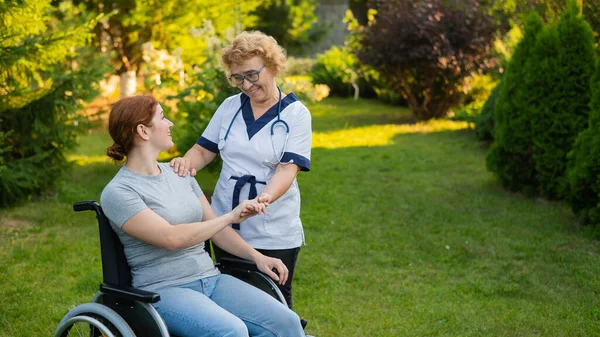 Elderly Female Nurse Walks Middle Aged Woman Wheelchair Park — Foto Stock