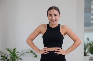 Beyaz arka planda gülümseyen Asyalı bir kadının portresi.