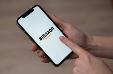 3 Aralık 2022 Almaty Kazakistan: Ekranda Amazon logosu olan yüzsüz kadın akıllı telefon tutuyor