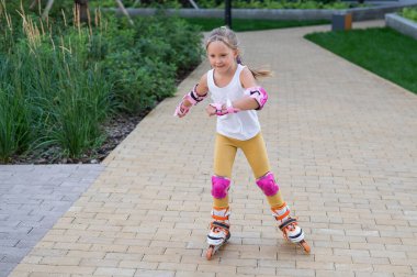 Küçük bir kız ve annesi açık hava spor sahasında briç oynuyorlar.