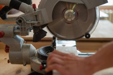 Usta atölyede dairesel testere ile tahtayı keser.