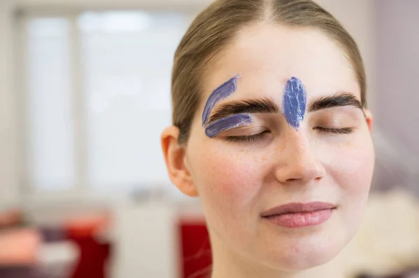 Young woman on eyebrow correction procedure with wax