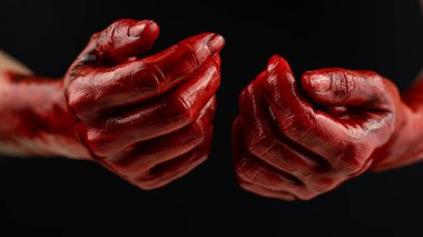Siyah bir arka planda kanlı kadın elleri