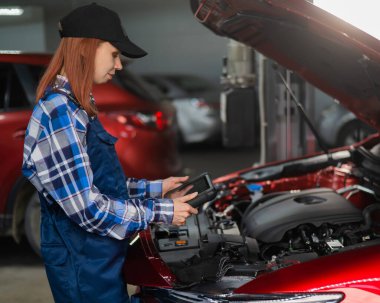 Kafkas kadın oto tamircisi hataları teşhis etmek için özel bir bilgisayar kullanıyor.