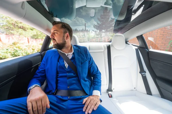 Caucasian Man Blue Suit Sits Back Seat Car Business Class — Stock Fotó