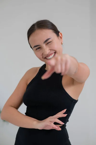 Smiling asian woman pointing her finger on white background