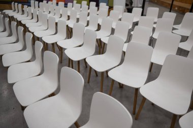 Empty white plastic chairs in a conference room