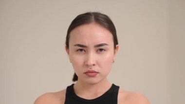 Portrait of a grimacing and smiling Asian woman on a white background