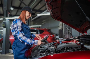 Kafkas kadın oto tamircisi hataları teşhis etmek için özel bir bilgisayar kullanıyor.