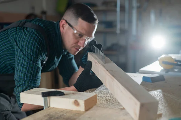 Carpinteiro Mede Uma Tábua Madeira Enquanto Trabalha Uma Oficina — Fotografia de Stock