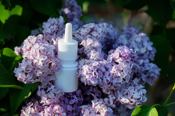 Nasal spray on blooming lilac. Allergy season