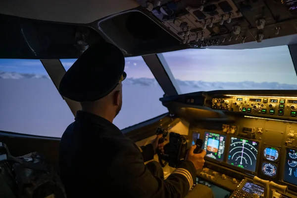 A man is studying to be a pilot in an aircraft simulator