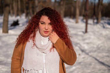Portrait of a chubby red-haired woman on a walk in winter