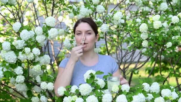 Kavkazská Žena Bere Antihistaminikum Vyjme Nosu Kolík Prádlo Poblíž Kvetoucího — Stock video