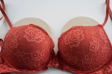 Beyaz arka planda turuncu sütyen takılı göğüs implantları