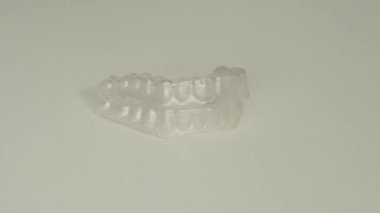 Şeffaf bir plastik hizalayıcı beyaz bir arkaplanda dönüyor