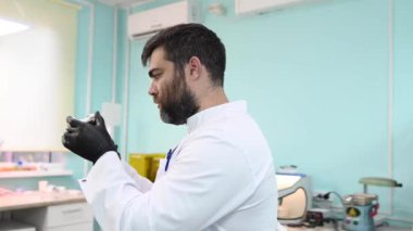 Diş teknisyeni elinde çenesinin kalıbını tutuyor.