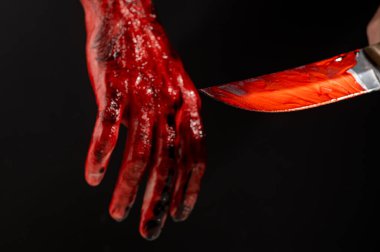 Siyah arka planda kanlı eli olan bir adam bıçak tutuyor.
