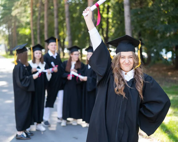 Группа Счастливых Студентов Выпускных Платьях Открытом Воздухе Молодая Девушка Дипломом — стоковое фото
