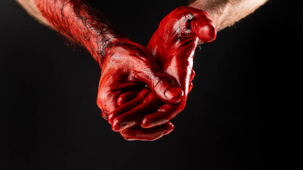Mens palms are stained with blood on a black background