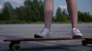 Beyaz bir kadın uzun bir sörf tahtası tutuyor.