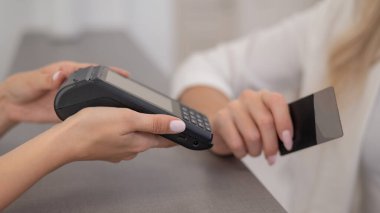 Woman paying with credit card using NFC contactless payment