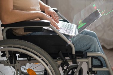 Tekerlekli sandalyedeki beyaz kadın laptopta çalışıyor. Yüksek çözünürlük menüsü. Borsa tabloları. Komisyon terminali