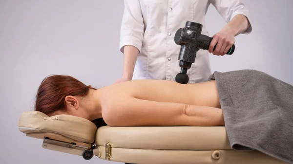 Medico Che Massaggia Schiena Una Paziente Con Una Pistola Massaggiatrice — Foto Stock