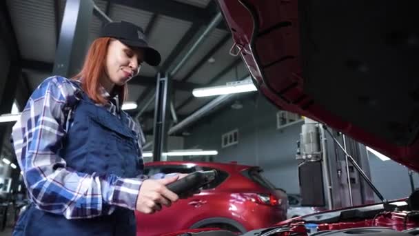 Καυκάσια Γυναίκα Μηχανικός Αυτοκινήτων Χρησιμοποιεί Έναν Ειδικό Υπολογιστή Για Εντοπίσει — Αρχείο Βίντεο