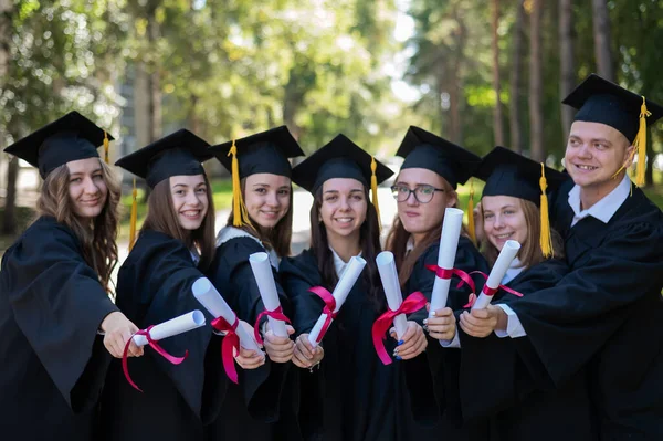 Row Happy Young People Graduation Gowns Holding Diplomas Outdoors — Stock Photo, Image