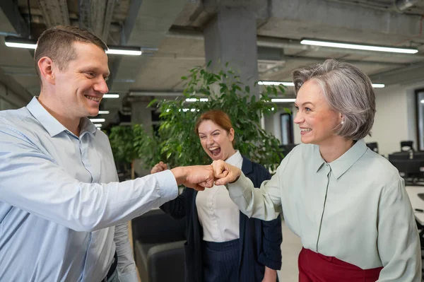 stock image Caucasian man bumping his fists with colleagues as a sign of success