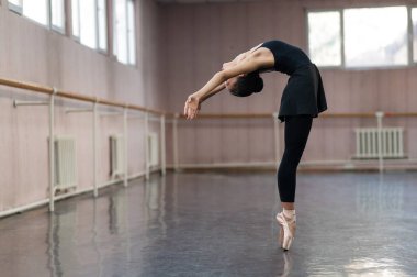 Asian woman dancing in ballet class. Bending in the back