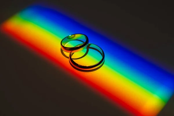 Rainbow beam on wedding rings. lgbt flag