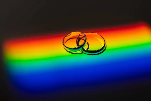 Rainbow beam on wedding rings. lgbt flag