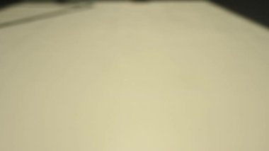 Mavi zarlar beyaz bir masaya ağır çekimde atılır.