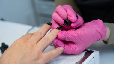 Manikür yaptıran bir adam güzellik salonunda tırnaklarını siyaha boyar.. 