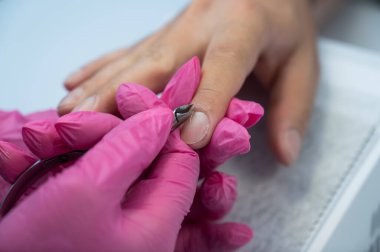 Manikürcü, erkek müşterinin tırnak etlerini meme uçlarıyla keser.