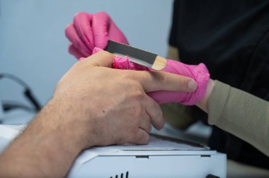 Man on a manicure procedure in a beauty salon