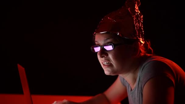 パラノイアの原因アジアの女性は コンピュータ上にタンパク質のキャップを着て入力します 陰謀説 — ストック動画